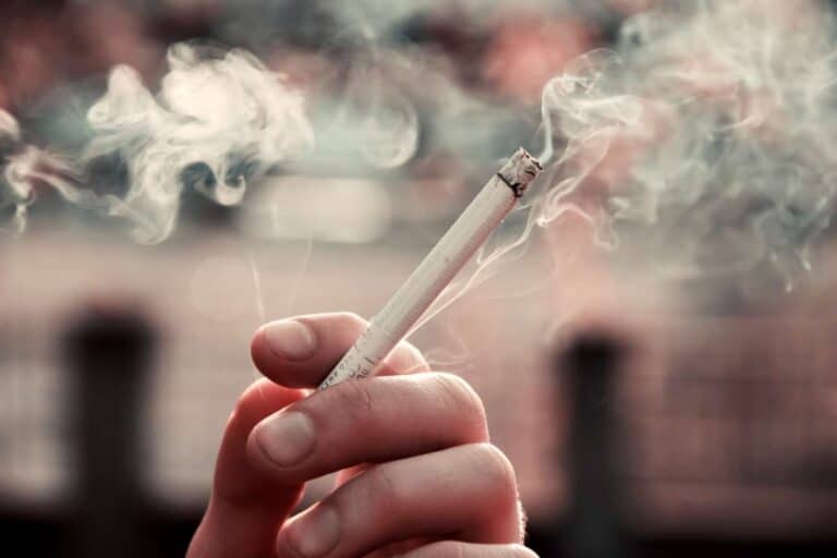 Main d'homme tenant une cigarette allumée