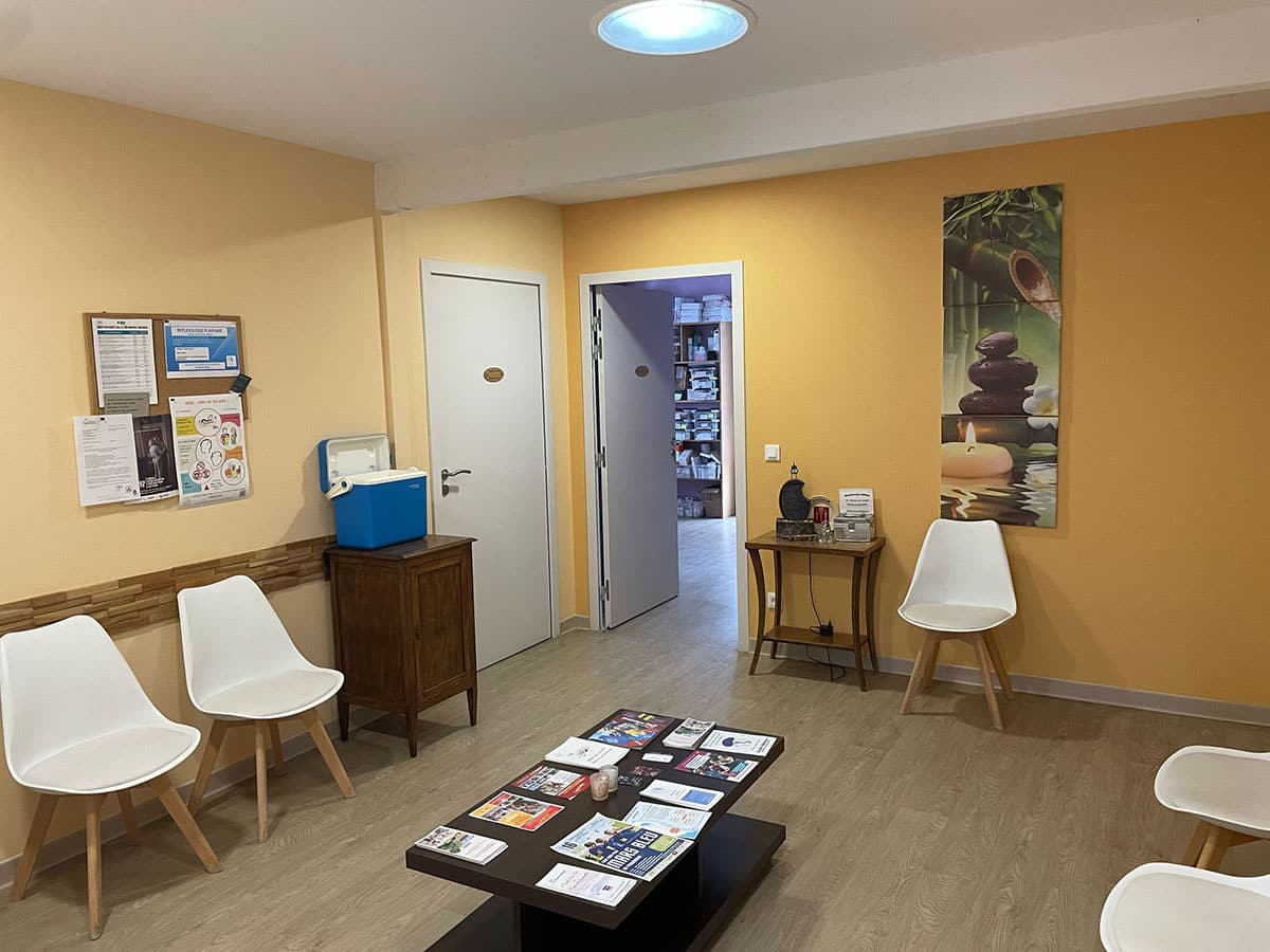 Praticien Reset Laser accueillant un client dans un centre pour une séance de réflexologie auriculaire au laser
