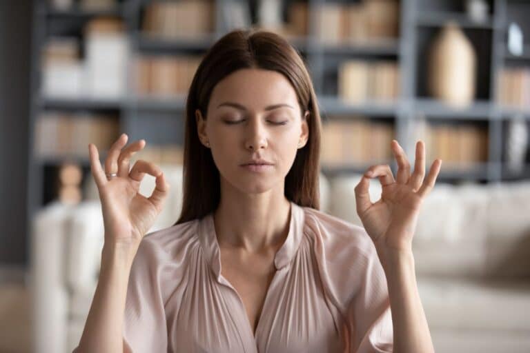 Femme faisant une position de yoga dans son salon
