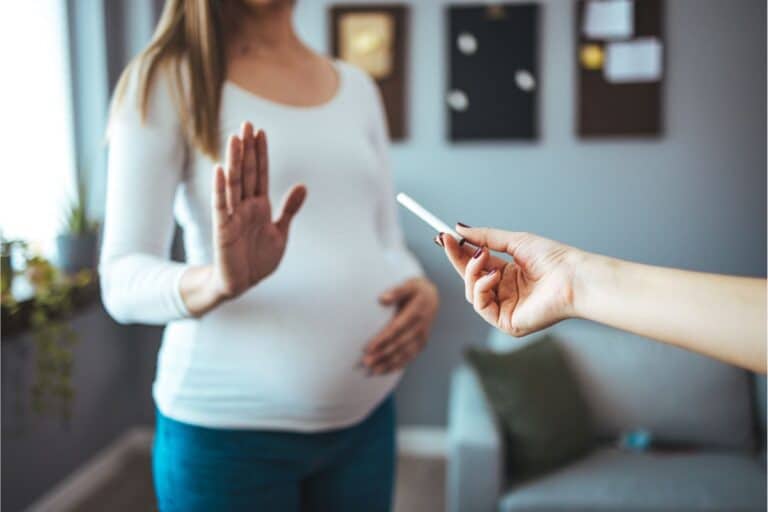 Femme enceinte refusant une cigarette qu'on lui tend