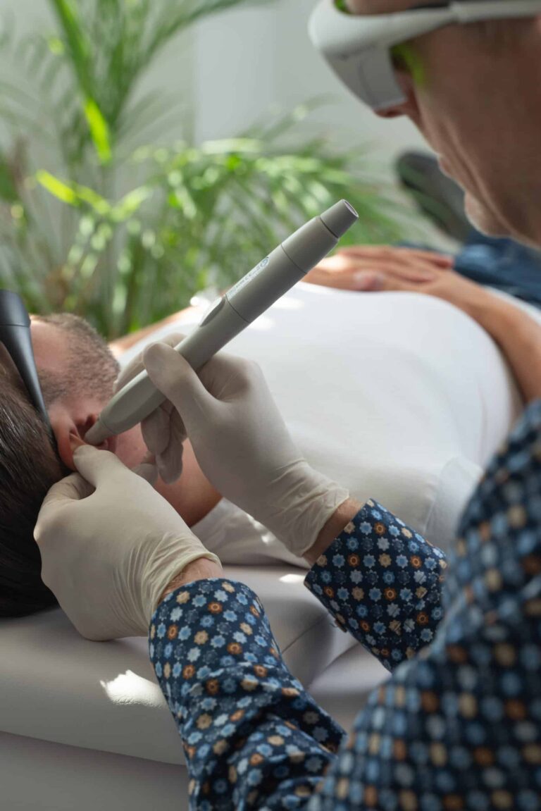 Praticien de Reset Laser en pleine séance laser anti-tabac sur un homme