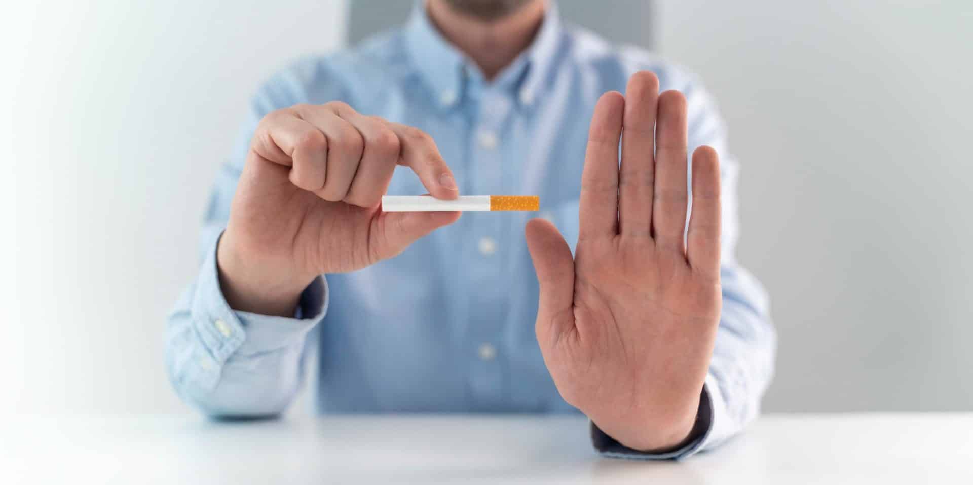 Un homme refuse une cigarette d'un geste de la main
