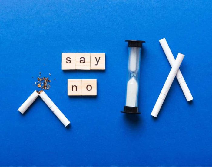 Sablier sur fond bleu avec cigarette cassée pour symboliser la durée du sevrage de tabac