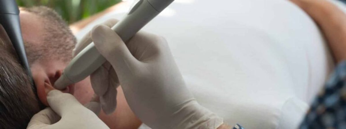 Praticien de Reset Laser en pleine séance laser anti-tabac sur un homme