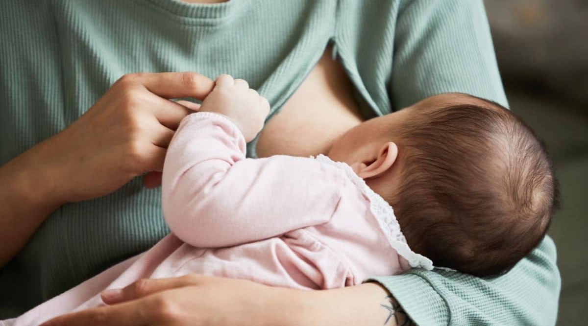 Bébé dans les bras de sa mère qui l'allaite