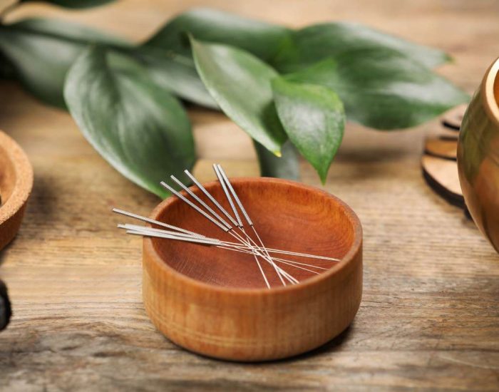 Epingles d'acupuncture dans un bol en bois utilisées pour arrêter de fumer naturellement