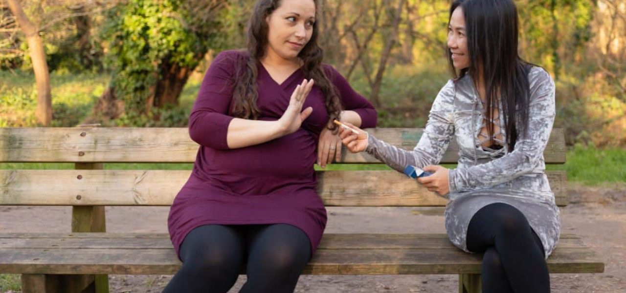 Femme proposant une cigarette à une amie pour maigrir